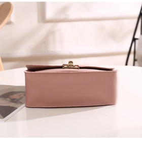 Side view of pink textured leather handbag with elegant gold metal twist-lock buckle