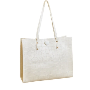 Minimalist beige crocodile embossed tote bag with gold rivets and long shoulder straps
