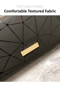 Detailaufnahme der schwarzen geometrischen Steppung mit poliertem goldenem Metallemblem