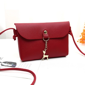 Mini red crossbody bag with cute deer pendant and pebbled faux leather finish