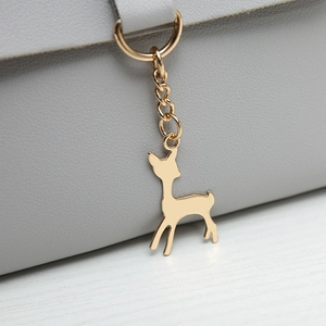 Gray leather mini crossbody bag featuring a delicate gold deer pendant decoration
