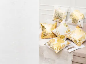 Dettaglio della federa bianca in peluche con stampa a caldo di foglia di monstera oro