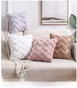 Detail of plush square throw pillows with wave texture in soft pink, white, and grey colors