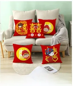 Macro detail of red wedding throw pillows with gold double happiness symbols on a sofa