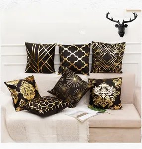 Detail of luxury black plush pillows with gold foil geometric and baroque patterns