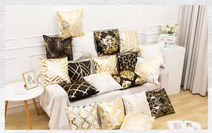 Detail showing plush black and gold throw pillow with marble pattern and luxury texture