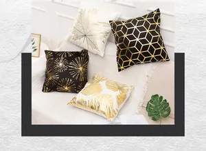 Detail of gold foil print cushion covers with geometric and leaf patterns on a white sofa