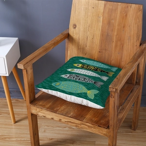 Green cushion cover with fish pattern on a wooden chair in a modern room setting