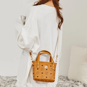 Braune Monogramm-Eimertasche mit goldenen Beschlägen und Tragegriff im Lifestyle-Look