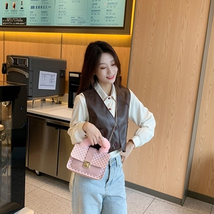 Pink crossbody bag with monogram pattern and pink faux fox fur handle in coffee shop