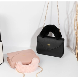 Detail view of plush handle bags in black and pink with elegant gold chain straps