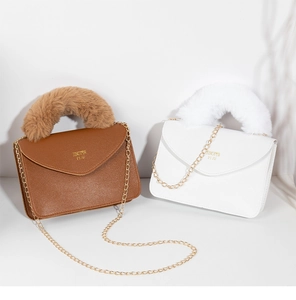 Detail of lychee pattern leather bags with faux fur handles and gold chain straps