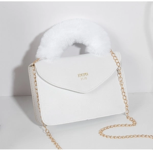 Detail of white leather small square bag with golden chain and fuzzy faux fur handle