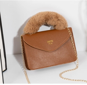 Detail of brown faux leather square bag with soft plush handle and golden chain strap