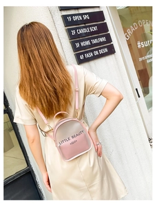 Close-up of clear PVC mini backpack with Little Beauty print and pink inner pouch