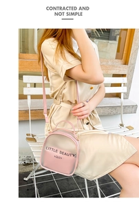 Detail of pink transparent shell backpack with 'LITTLE BEAUTY' pouch on outdoor bench