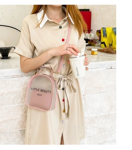 Pink semi-transparent mini round crossbody bag with Little Beauty print on lifestyle model