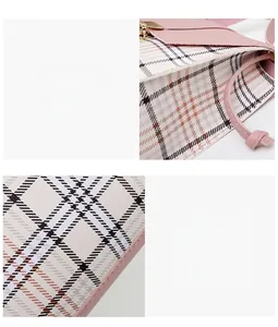Close-up of pink stitching and plaid textured leather on a mini crossbody bag