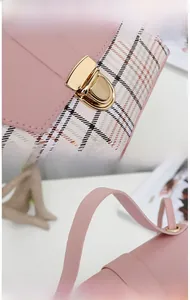 Detail of pink plaid mini bag showing golden metal lock and smooth leather handle