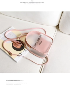 Pink translucent frosted mini backpack featuring Little Beauty lettering on a white sofa