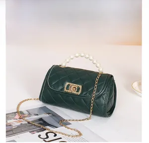 Detail of green quilted mini bag with pearl handle and golden chain strap display