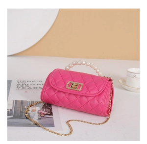 Detailed view of rose pink quilted handbag with large pearl handle and gold chain strap