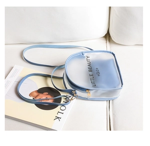 Light blue frosted translucent mini crossbody bag with black typography on white sofa