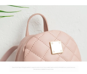 Detail einer rosa gesteppten Ledertasche mit Rautenmuster und goldener Metallplatte