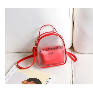 Detail of red frosted transparent dual-bag set on white sofa with magazine