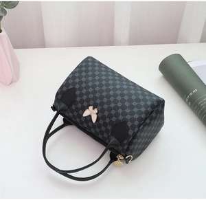 Detail view of black Boston bag with gray geometric pattern and white butterfly charm