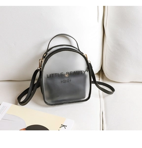 Detail view of transparent mini backpack on white sofa showing the inner black pouch