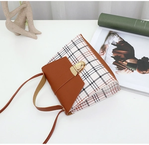 Detailed shot of vintage plaid crossbody bag with brown leather flap and gold turn-lock