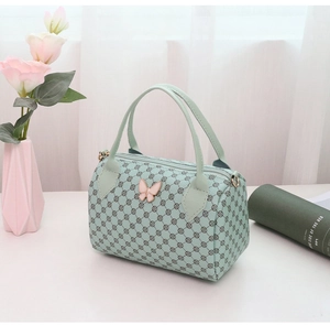 Detail of mint green Boston bag featuring pink butterfly buckle and circular logo pattern