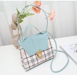Detail view of plaid mini crossbody bag with light blue flap and golden metal clasp