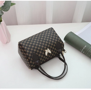 Detail of Boston bag with geometric floral pattern and white butterfly hardware