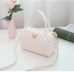 Detailed view of Boston handbag with yellow dots and a gold butterfly metal clasp