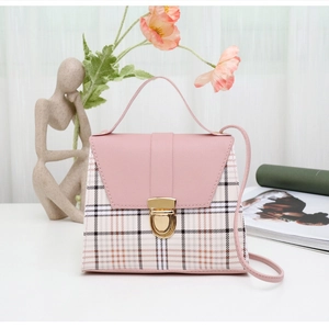 Detail of pink plaid mini crossbody bag with golden shield lock and fine texture