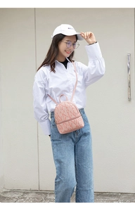 Roze kleine rugzak met Luckyvg letteropdruk gedragen als stijlvolle crossbody