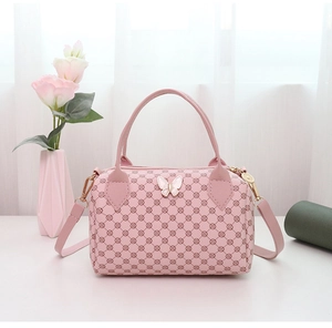 Detailed close-up of a pink Boston bag with geometric prints and white butterfly decor