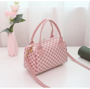 Detailed view of a pink Boston bag with geometric patterns and golden metal hardware