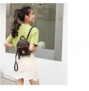Detailed view of mini checkered backpack with front flap pocket and gold metal buckle