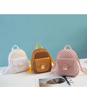 Detailed row of mini patterned backpacks in white, brown, and pink with gold clasps