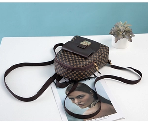 Detail of small dark brown backpack with gold metal clasp and circular dot patterns