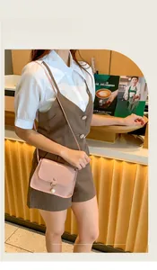 Petit sac rose à motif crocodile avec perle porté à l'épaule dans un café