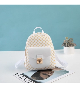 Close-up of mini white backpack with yellow grid pattern and golden metal lock