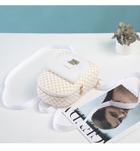 Close-up of white and yellow mini backpack with gold buckle and stylish fabric strap