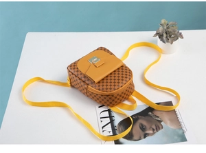 Detail view of mini backpack featuring monogram print and bright yellow flap pocket
