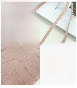 Détails de la texture effet croco rose et coutures précises sur le petit sac à main