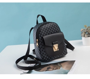 Detail of grey geometric pattern backpack with black faux leather flap and gold buckle