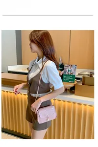 Détail du petit sac bandoulière rose effet crocodile avec pendentif perle élégant